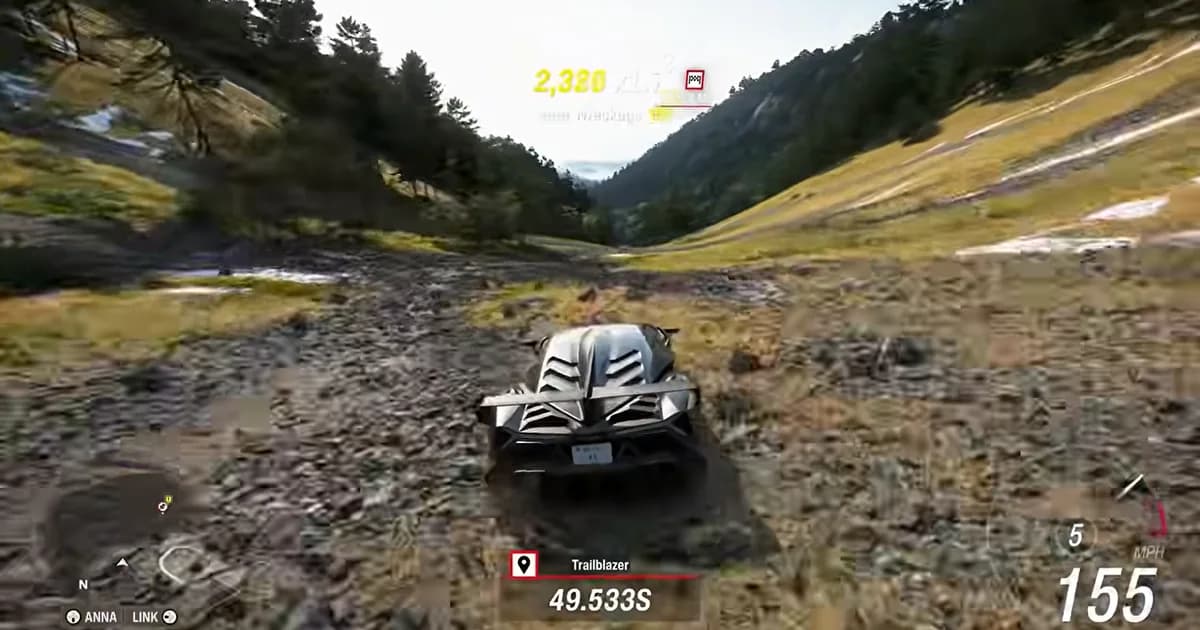 A hypercar speeds across a rocky mountain valley during an off-road Trailblazer event.